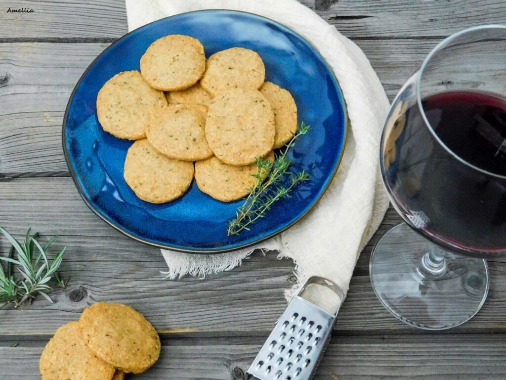 Pohled na sušenky na talířku a vedle sklenice s vínem